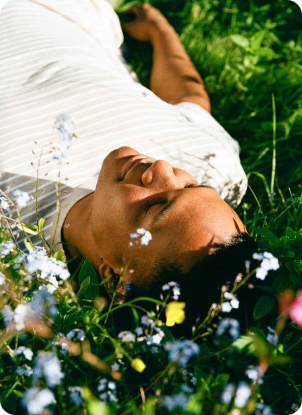 Resting on green grass among small white flowers, at ease