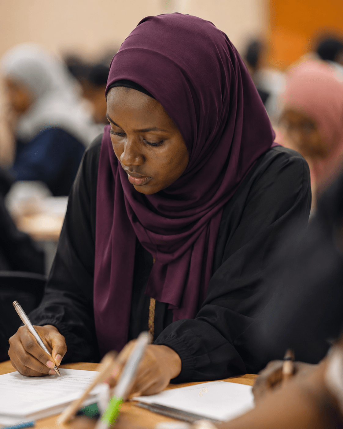 A woman working quietly at a table during a Heyrafiki session