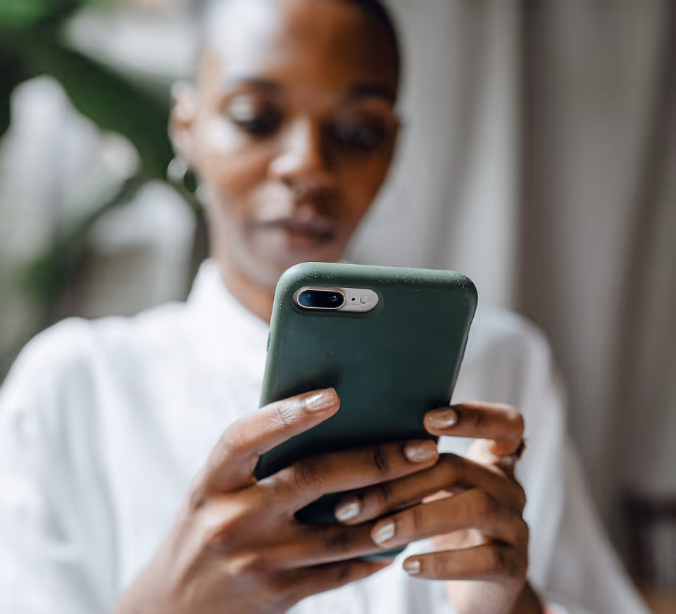 A woman using her phone in soft indoor light